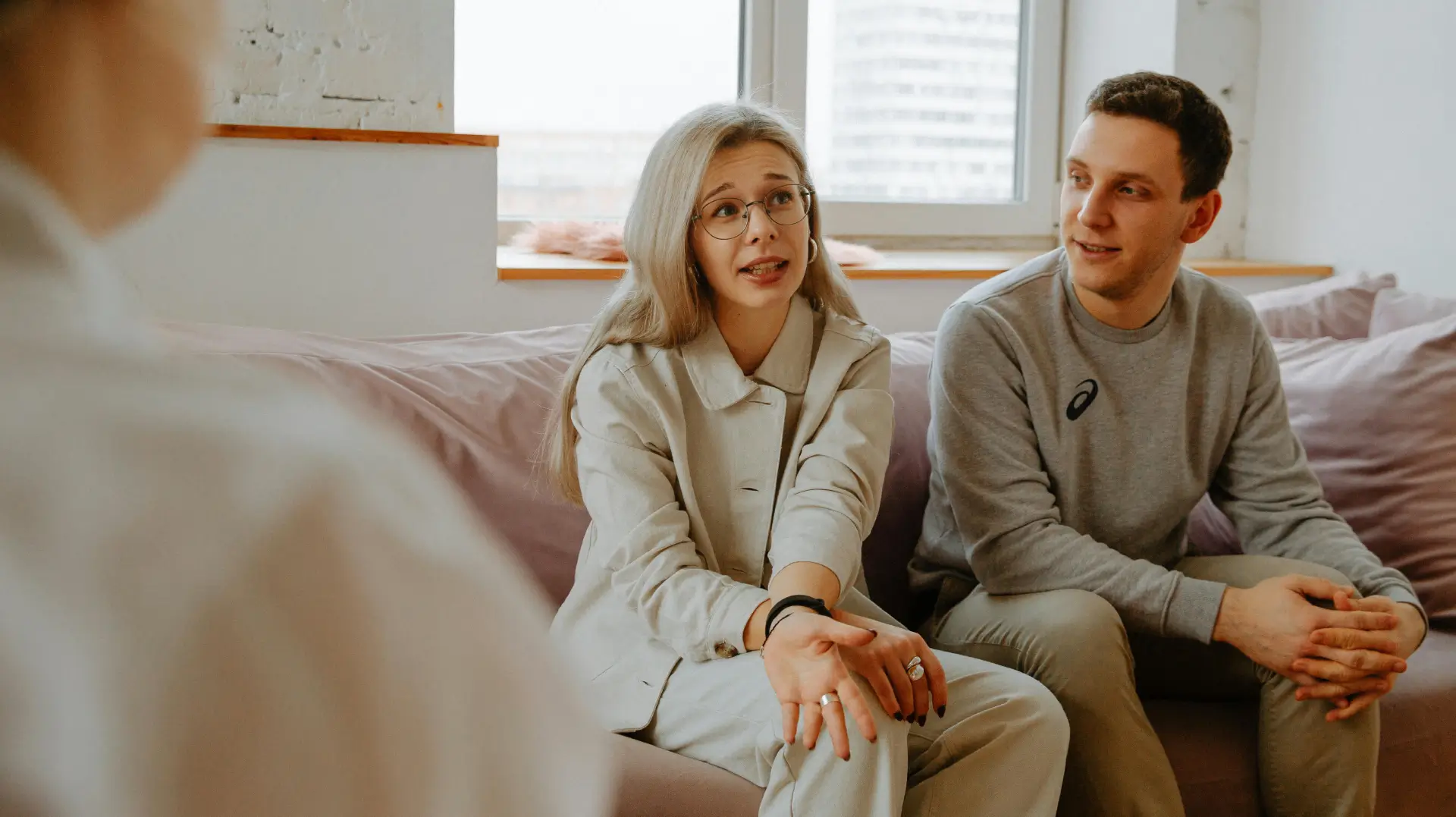 A woman sitting on the couch next to a man.